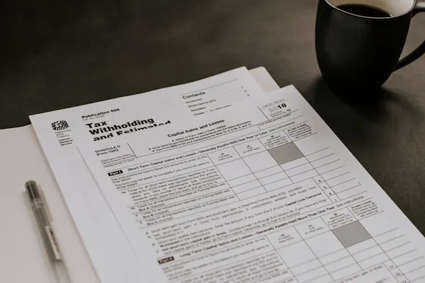 Tax withholding documents and pen on a desk